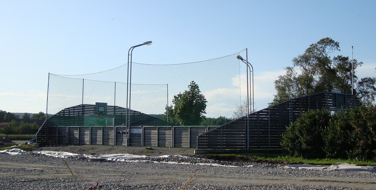 Innhegnet ballbinge med nett og lysmaster.