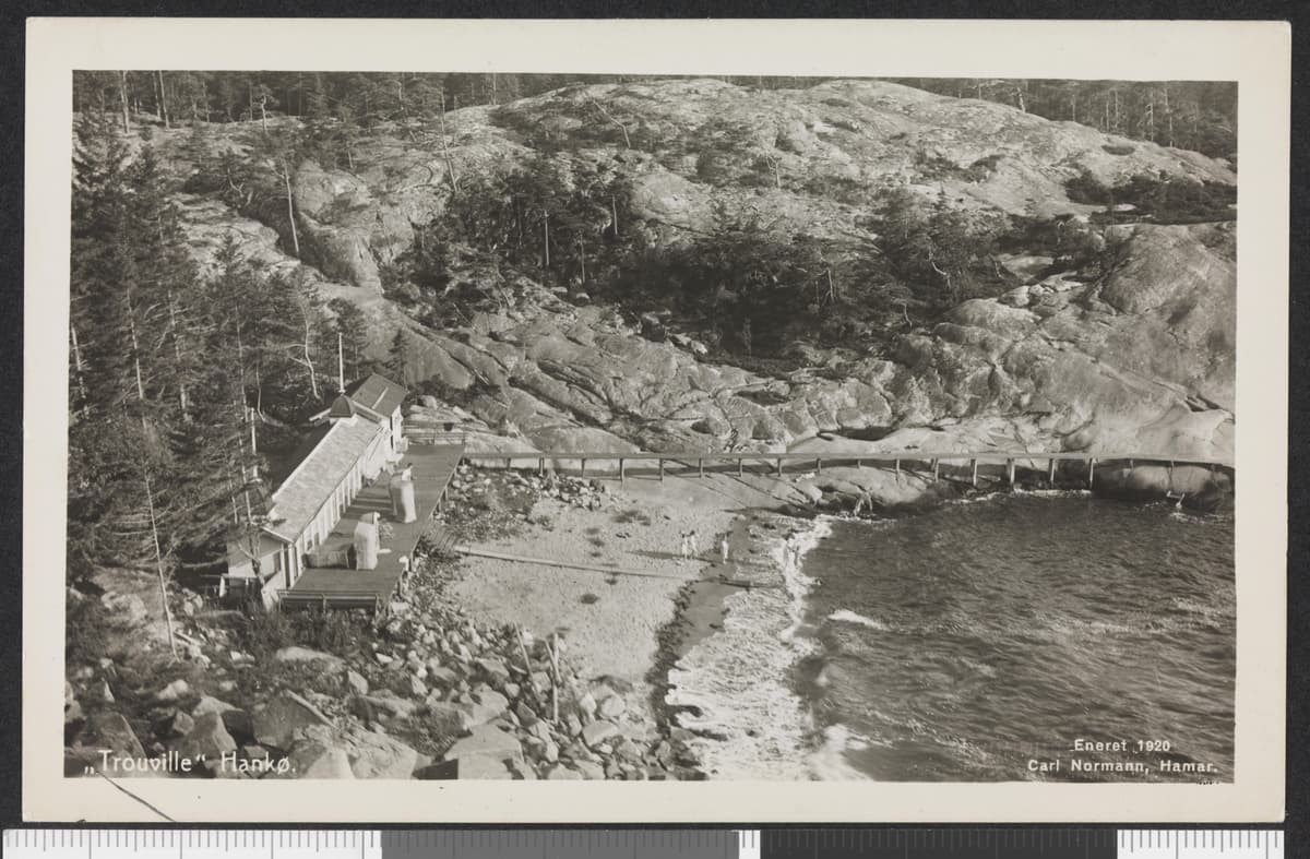Historisk svart-hvitt postkort fra Hankø med badehus langs en steinete strand.
