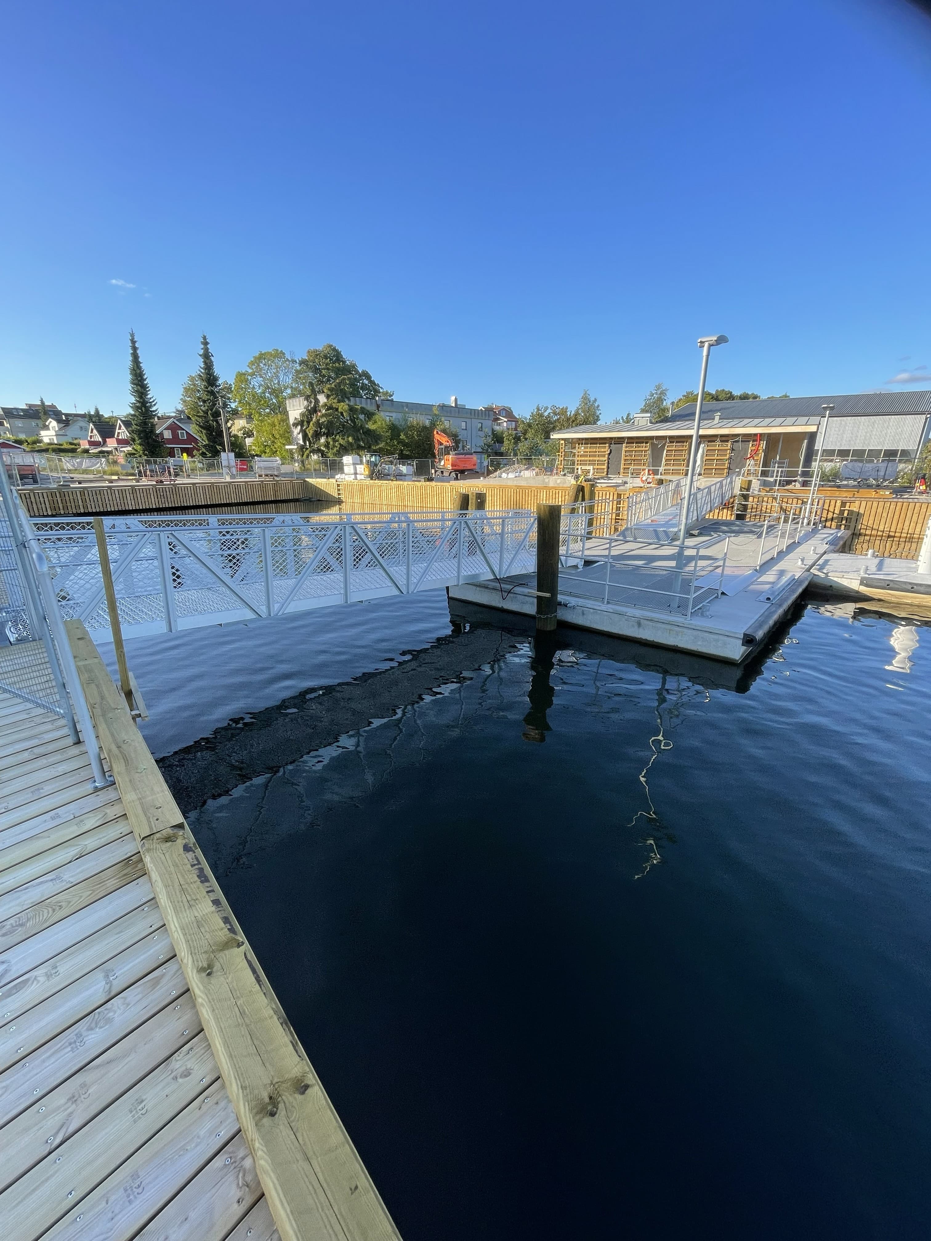Gressvik fergeleie under ombygging, med ny trebrygge og flytekai og Fredrikstad sentrum på andre siden av Glomma.