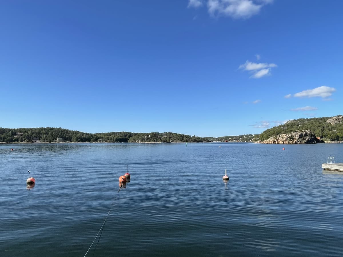 Hankøsundet sett nordover fra Onsøy-siden en solrik sommerdag, med fortøyningsbøyer i forgrunnen.